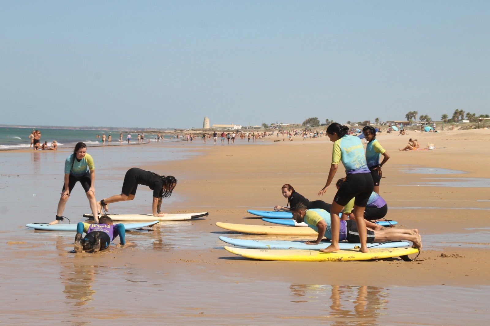 Clase de surf calentando en la arena de la playa de Zahara de los Atunes
